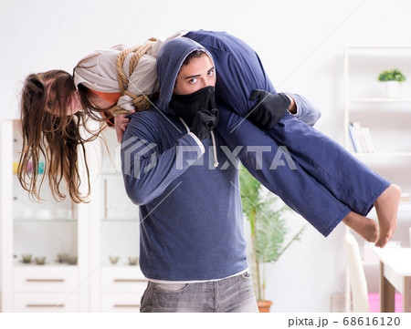 Armed man assaulting young woman at home 68616120