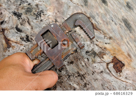 Long nose pliers and adjustable wrench on wood grain background. Long nose pliers and adjustable wrench on wood grain background. 68616329
