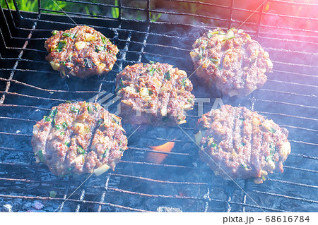 Burger Patties Cooking on Smoking Barbecue Grill. cooking meat on coals Burger Patties Cooking on Smoking Barbecue Grill. cooking meat on coals 68616784