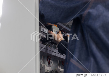 Industrial production of an electricity panel boards - man worker doing something with opened board 68616793
