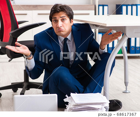 Tired exhausted businessman working overtime in office Tired exhausted businessman working overtime in office 68617367