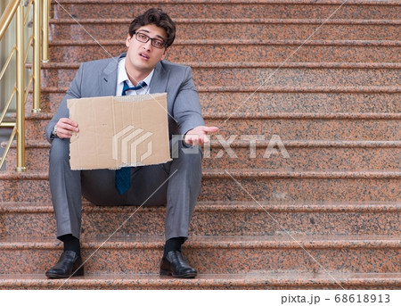 Desperate businessman begging on the street 68618913