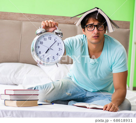 Student preparing for exams at home in bedroom sitting on the be Student preparing for exams at home in bedroom sitting on the be 68618931