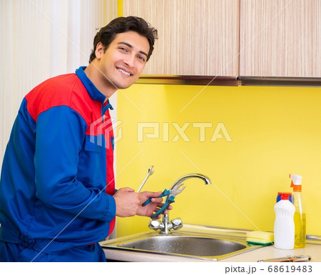 Plumber repairing tap at kitchen Plumber repairing tap at kitchen 68619483