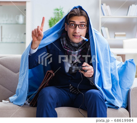 Employee suffering from flue playing computer game at home Employee suffering from flue playing computer game at home 68619984