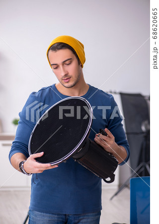 Young male photographer working in the studio Young male photographer working in the studio 68620665