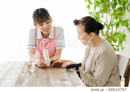 薬ケースの説明をする介護士 68620767