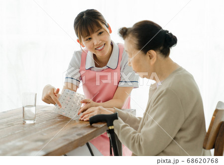 薬ケースの説明をする介護士 68620768