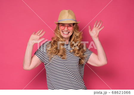 woman wear sunglasses and hat smiling and waving palm saying hello. woman wear sunglasses and hat smiling and waving palm saying hello. 68621066