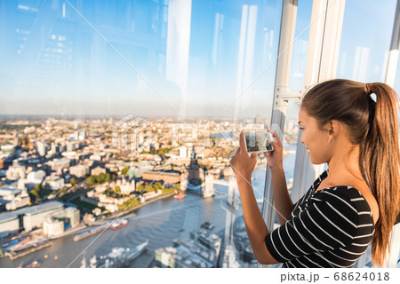 Tourist girl taking phone picture of sunset london skyline view from The Shard. Europe travel tourism Tourist girl taking phone picture of sunset london skyline view from The Shard. Europe travel tourism 68624018