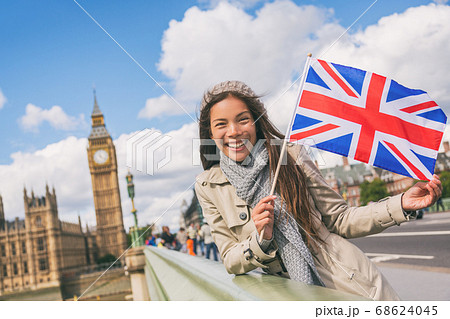 London travel tourist woman showing Union flag Great Britain british UK flag. Asian girl at Big Ben on Westminster bridge on Europe holidays holding icon at iconic landmark London travel tourist woman showing Union flag Great Britain british UK flag. Asian girl at Big Ben on Westminster bridge on Europe holidays holding icon at iconic landmark 68624045
