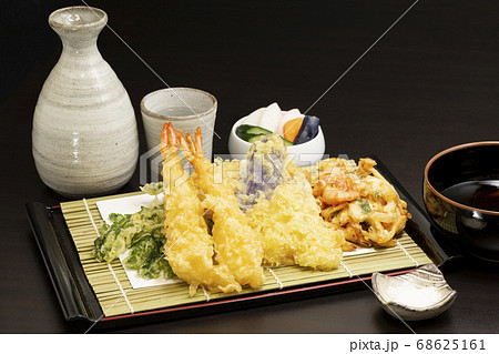 天ぷらの盛り合わせと日本酒 エビ キス ナス 春菊 かき揚げの写真素材