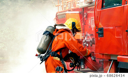 Firefighter fighting with flame using fire hose Firefighter fighting with flame using fire hose 68626434
