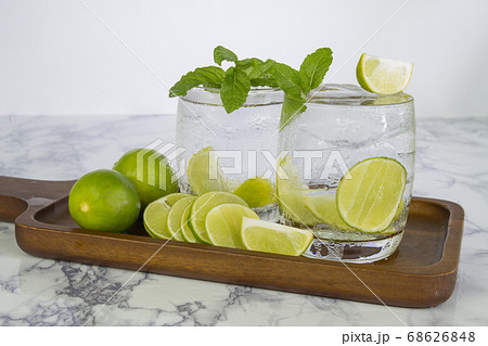 Cold Drink from Lemon cut into pieces in water glass on wood cup Cold Drink from Lemon cut into pieces in water glass on wood cup 68626848