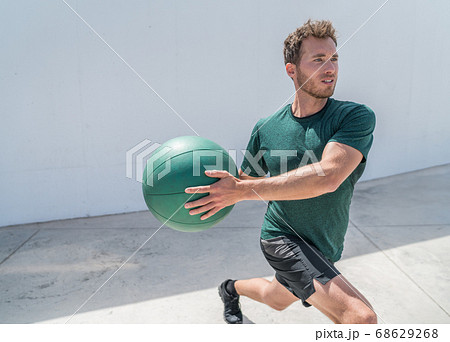 Man exercising with medicine ball weight at gym Man exercising with medicine ball weight at gym 68629268