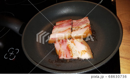photo pieces of bacon are fried in a black frying 68630736