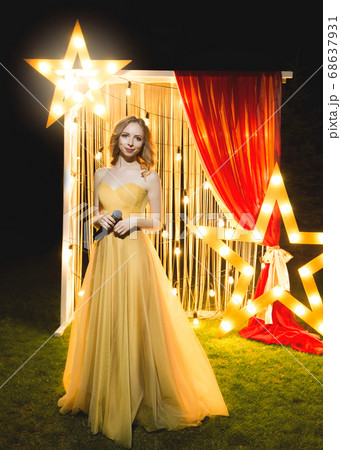 Presenter woman in dress with microphone. Emcee 68637931