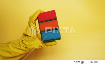 Hand in glove holding few washing sponges - amount of housework concept 68640186