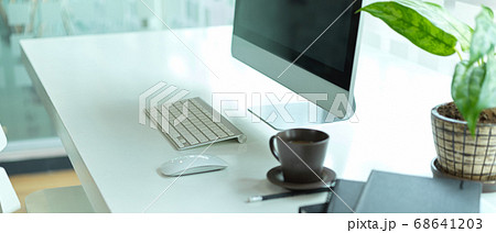 Side view of working table with computer, coffee 68641203