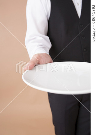 皿を運ぶウェイター 68641892