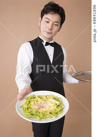 料理を運ぶウェイター 68641896