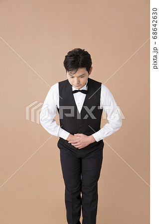 お辞儀をするウェイター 68642630