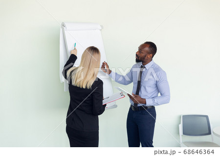 Young businessman working with colleague using flipchart, copyspace 68646364
