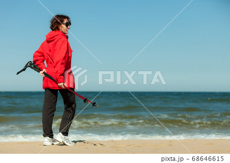 Nordic walking. Woman hiking on the beach. Nordic walking. Woman hiking on the beach. 68646615