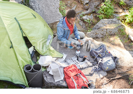 Woman drinking tea during camping 68646875