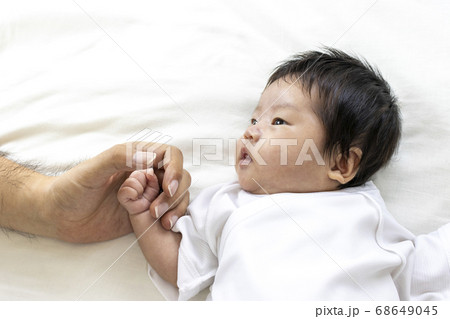 赤ちゃんと手をつなぐ男性の手 68649045