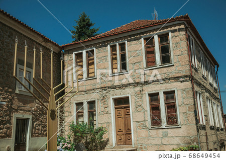 Stone house and metal sculpture in menorah shape Stone house and metal sculpture in menorah shape 68649454
