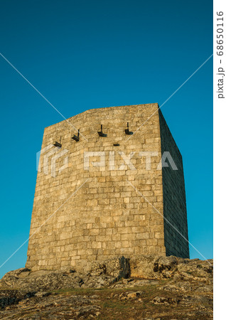 Stone square tower over rocky hill on sunset Stone square tower over rocky hill on sunset 68650116