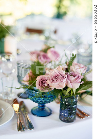 Powder roses in small blue vases.Wedding decor or romantic date design. Floristics. 68650302