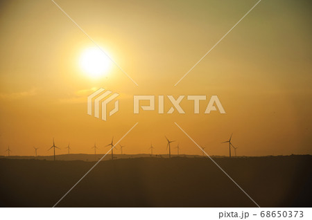 Landscape and several wind turbines silhouettes on sunset Landscape and several wind turbines silhouettes on sunset 68650373
