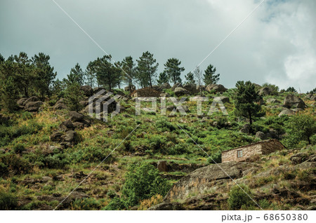 Rustic stone house on a hilly landscape 68650380