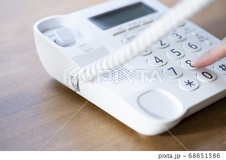 Female hand making a call from landline - Stock Photo [68651586