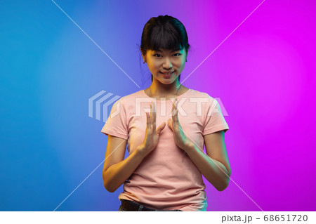 Asian young woman's portrait on gradient studio background in neon Asian young woman's portrait on gradient studio background in neon 68651720