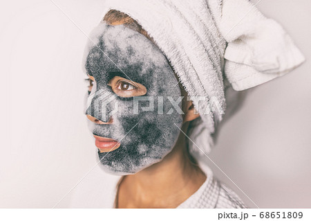 Bubble foam mask woman doing facial beauty treatment with charcoal detox purifying face pores product in home bathroom Bubble foam mask woman doing facial beauty treatment with charcoal detox purifying face pores product in home bathroom 68651809