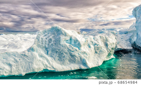 Global Warming and Climate Change - Icebergs from melting glacier in icefjord in Ilulissat, Greenland. Aerial video of arctic nature iceberg and ice landscape. Unesco World Heritage Site 68654984