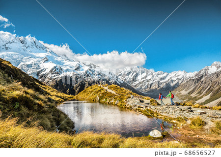 Hiking travel nature hikers in New Zealand. Couple people walking on Sealy Tarns hike trail route with Mount Cook landscape, famous tourist attraction Hiking travel nature hikers in New Zealand. Couple people walking on Sealy Tarns hike trail route with Mount Cook landscape, famous tourist attraction 68656527