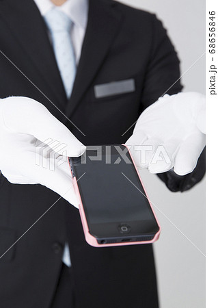 忘れ物を渡すフロントスタッフ 68656846