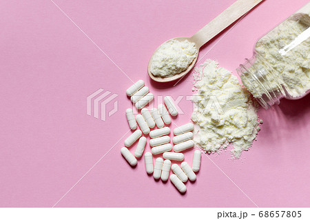 Dietary Supplement in powder and pills on a pink background. Top view, horizontally with space 68657805