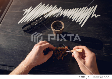 Cropped view of preparing tobacco for shisha on table outside Cropped view of preparing tobacco for shisha on table outside 68658722