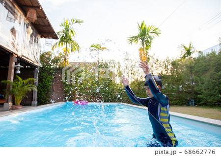 Asian child girl wearing swimming suit playing water in the swimming pool 68662776