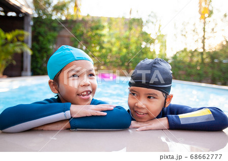 Two asian child girls in the swimming pool and playing water together with fun Two asian child girls in the swimming pool and playing water together with fun 68662777