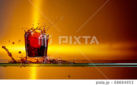Slice of lemon and ice pieces falling into a glass Slice of lemon and ice pieces falling into a glass 68664953