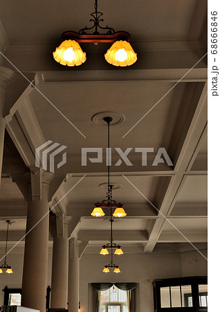 下関市にある旧秋田商会ビルの高い天井模様とレトロな雰囲気が漂う照明群の風景の写真素材