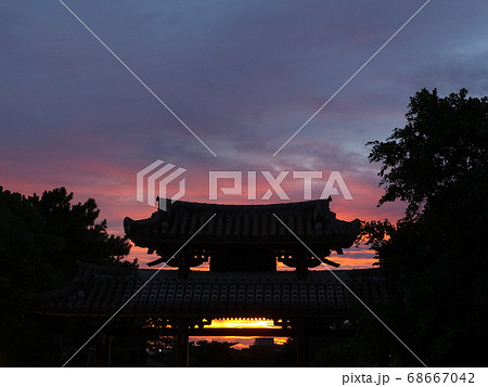 夕焼けと首里城守礼門の影の写真素材