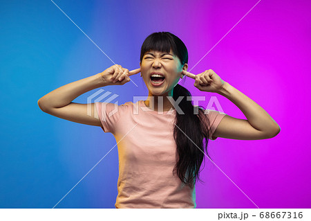 Asian young woman's portrait on gradient studio background in neon Asian young woman's portrait on gradient studio background in neon 68667316