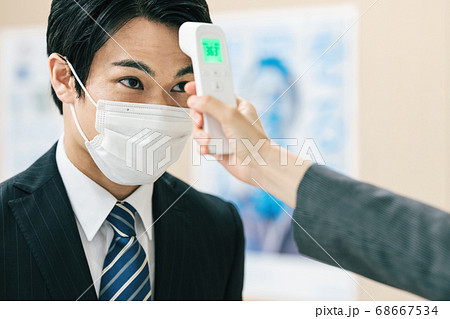 スーツを着た男性の検温シーン 68667534